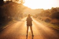 Young backpacking adventurous woman hitchhiking on the road.Ready for adventure of life.Travel lifestyle.Low budget traveling.Adve Royalty Free Stock Photo