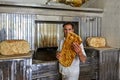 Young baker demonstrates Iranian flatbread barbari while inside