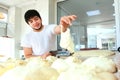 A young Baker puts a portion of dough on the table. My hands are out of focus. Yeast dough in the hands of a Baker. The process of