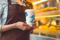 Young baker in uniform with coffee