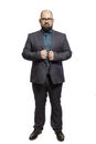 Young bald bearded man with glasses and a full-length suit. Isolated over white background. Royalty Free Stock Photo