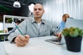 Young bald business man sitting at desk in office, working on computer Royalty Free Stock Photo