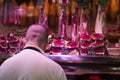 Young bald butcher cutting meat with the big special knife at the famous market at Barcelona, Catalonia, Spain 2019-04