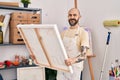 Young bald man artist smiling confident looking draw at art studio Royalty Free Stock Photo