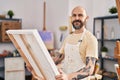 Young bald man artist smiling confident looking draw at art studio Royalty Free Stock Photo