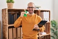 Young bald man with beard holding support green ribbon winking looking at the camera with sexy expression, cheerful and happy face Royalty Free Stock Photo