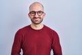 Young bald man with beard standing over white background wearing glasses with hands together and crossed fingers smiling relaxed Royalty Free Stock Photo