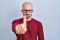 Young bald man with beard standing over white background wearing glasses pointing with finger up and angry expression, showing no Royalty Free Stock Photo