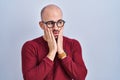 Young bald man with beard standing over white background wearing glasses tired hands covering face, depression and sadness, upset Royalty Free Stock Photo