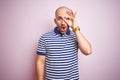 Young bald man with beard wearing casual striped blue t-shirt over pink isolated background doing ok gesture shocked with Royalty Free Stock Photo