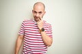 Young bald man with beard wearing casual striped red t-shirt over white isolated background Pointing to the eye watching you Royalty Free Stock Photo