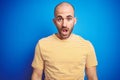 Young bald man with beard wearing casual t-shirt over blue isolated background afraid and shocked with surprise expression, fear Royalty Free Stock Photo