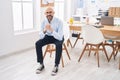 Young bald man business worker smiling confident sitting on chair at office Royalty Free Stock Photo