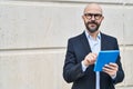 Young bald man business worker smiling confident using touchpad at street Royalty Free Stock Photo