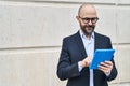 Young bald man business worker smiling confident using touchpad at street Royalty Free Stock Photo