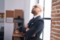 Young bald man business worker standing with arms crossed gesture and serious expression at office Royalty Free Stock Photo