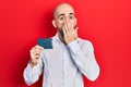 Young bald man holding ssd memory covering mouth with hand, shocked and afraid for mistake Royalty Free Stock Photo