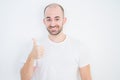 Young bald man over white isolated background doing happy thumbs up gesture with hand Royalty Free Stock Photo
