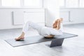 Young bald man performing complex yoga pose through online instructions