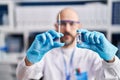 Young bald man scientist holding syringe and dose vaccine at laboratory