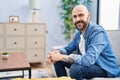 Young bald man smiling confident sitting on sofa at home Royalty Free Stock Photo