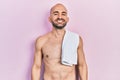 Young bald man standing shirtless with a happy and cool smile on face