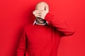 Young bald man wearing casual clothes and glasses smiling and laughing with hand on face covering eyes for surprise Royalty Free Stock Photo