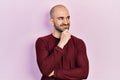 Young bald man wearing casual clothes with hand on chin thinking about question, pensive expression Royalty Free Stock Photo