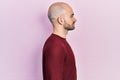Young bald man wearing casual clothes looking to side, relax profile pose with natural face with confident smile Royalty Free Stock Photo