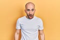 Young bald man wearing casual white t shirt afraid and shocked with surprise and amazed expression, fear and excited face Royalty Free Stock Photo