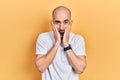 Young bald man wearing casual white t shirt afraid and shocked, surprise and amazed expression with hands on face Royalty Free Stock Photo