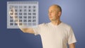 Young bald man work with virtual calendar. Male choice two date for start and end period. Planing perioad for rest or Royalty Free Stock Photo