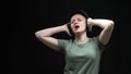 Young bald woman with headphones dancing on a black background