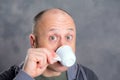 Young baldheaded man drinking coffee