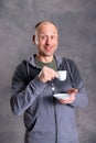 Young baldheaded man drinking coffee