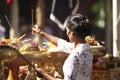 A young Balinese woman putting scents in traditional clothes on Hindu Temple ceremony, Bali Island, Indonesia