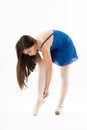 Young ballerina bending down tying her shoes