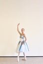 A young ballerina in a dress practicing ballet poses in the studio Royalty Free Stock Photo