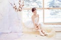 Young ballerina girl is preparing for a ballet performance. Little prima ballet. Girl in a white ball gown and Pointe