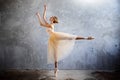 Young ballerina in a golden colored dancing costume is posing in a loft studio Royalty Free Stock Photo