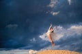 Young ballerina in a light long white dress flies in a jump