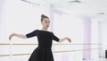 Young ballerina makes beautiful movements with her hands.