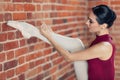 Young ballerina with raised leg tying the ribbon in her shoes Royalty Free Stock Photo