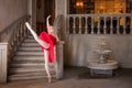 Young ballerina in a red tutu is dancing against background of the theatrical scenery of the palace Royalty Free Stock Photo