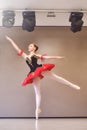 A young ballerina stands gracefully in pointe shoes on her toes in the studio.Ballet student practicing classical dance in studio Royalty Free Stock Photo