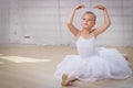 Young ballerina in white clothes sitting on the floor Royalty Free Stock Photo
