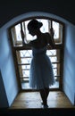 Young ballerina in white dress and satin ballet shoes posing on a old window in a dark room Royalty Free Stock Photo