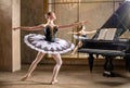 Young ballerina in a white tutu dancing on beautiful old piano in a vintage interior Royalty Free Stock Photo