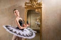 Young ballerina in a white tutu poses near beautiful old mummer in vintage interior, reflecting many times Royalty Free Stock Photo