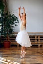 Young ballerina in white tutu practicing dance moves. Royalty Free Stock Photo